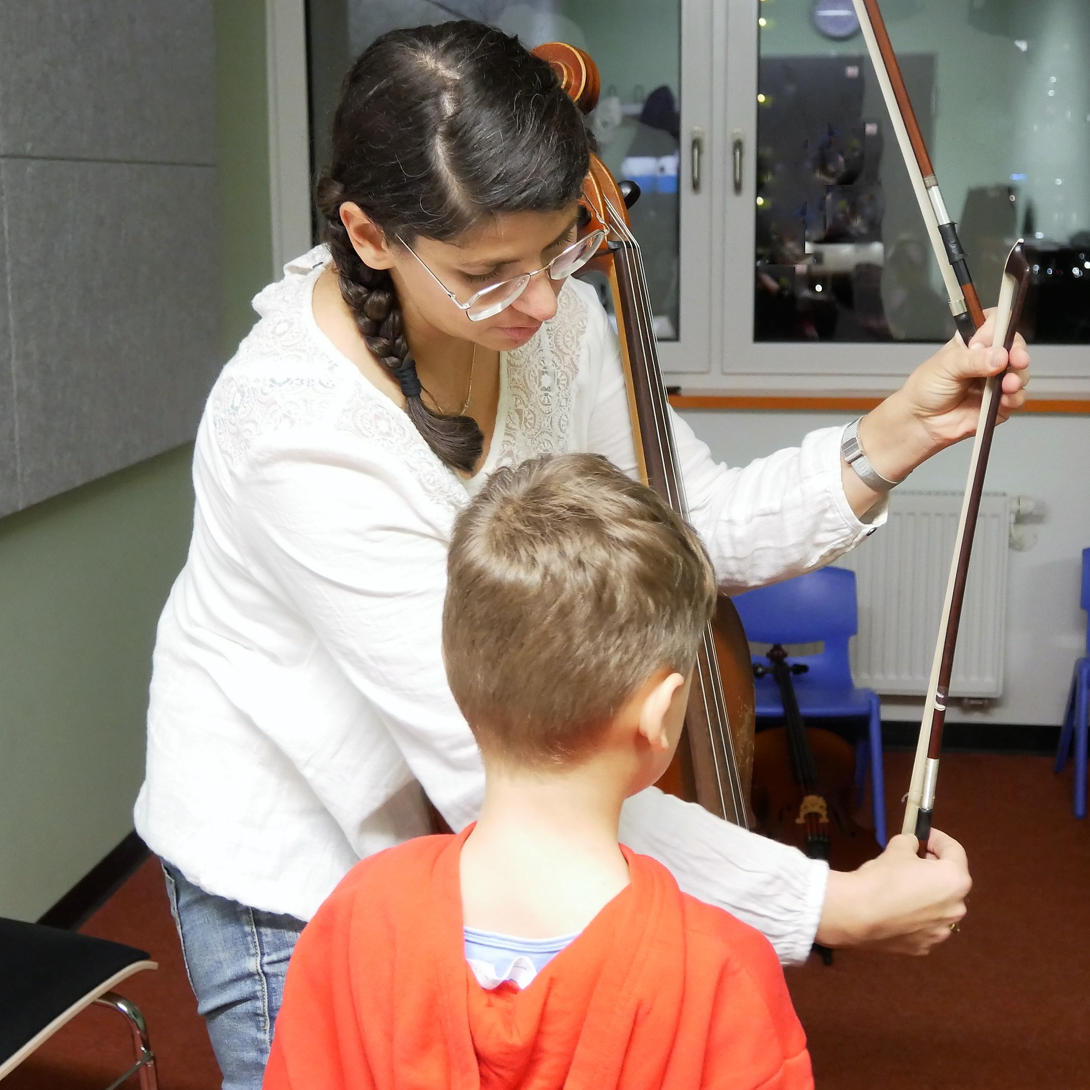 Cello-Lehrerin Albena Polei zeigt einem Kind an der Musikschule Hoyerswerda, wie der Bogen gehalten wird.  