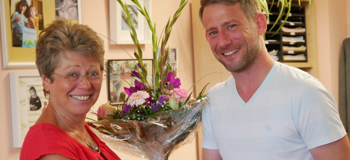 Nik Kevin Koch, Leiter der Musikschule Hoyerswerda, übergibt einen Blumenstrauß an Thea Hanspach, die seit 40 Jahren an der Musikschule Hoyerswerda unterrichtet.
